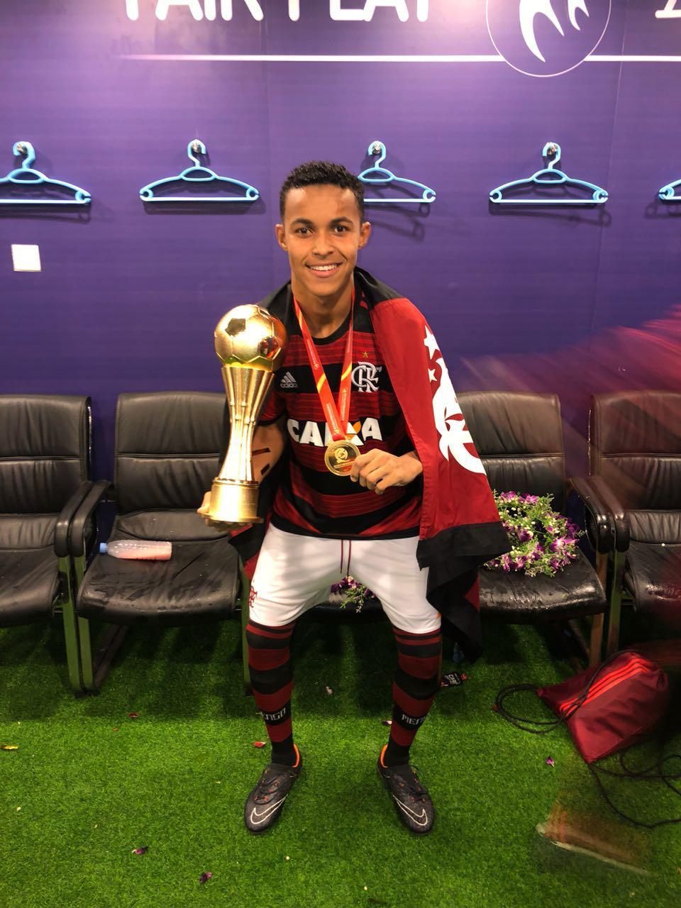Lázaro como atleta profissional do Flamengo segurando troféu